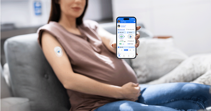 mẹ bầu gắn cgm cầm điện thoại hiển thị ứng dụng theo dõi đường huyết fpt